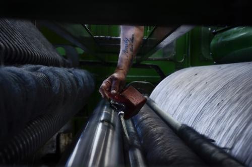 Photograph: Tim Smith| Oiling a machine that disentangles the wool fibres and converts them into a form ready for spinning into yarn at Abraham Moon & Sons.